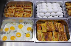 four trays of eggs and other breakfast foods at Ani Central Inn in Yerevan