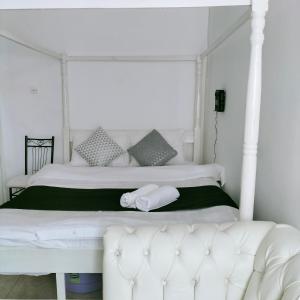 a bedroom with a white bed with a white couch at Johari Suites and Shared Studio Westlands in Nairobi
