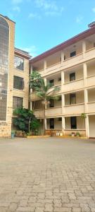 een groot gebouw met palmbomen ervoor bij Johari Shared Studio Westlands in Nairobi
