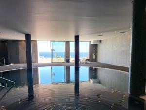 - une piscine d'eau dans un bâtiment avec vue sur l'océan dans l'établissement Hotel Royal Orchid, à Caniço
