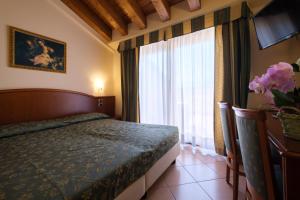 ein Schlafzimmer mit einem Bett und einem großen Fenster in der Unterkunft Garda Family House in Brenzone sul Garda