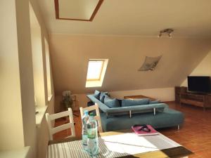 een woonkamer met een blauwe bank en een tafel bij Ferienwohnung Ostseezeit - in ruhiger Lage in Nienhagen