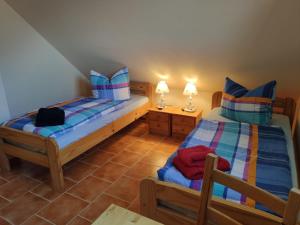 een slaapkamer met 2 bedden en 2 lampen op tafels bij Ferienwohnung Ostseezeit - in ruhiger Lage in Nienhagen