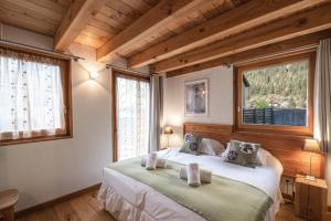 1 dormitorio con 1 cama y 2 ventanas en Chalet Gaia en Chamonix-Mont-Blanc