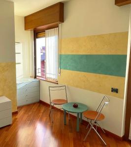 Habitación con mesa, 2 sillas y ventana en B&B Adelaide en Brescia