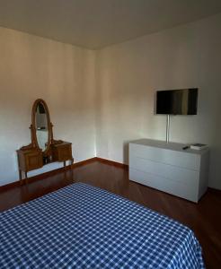 1 dormitorio con 1 cama, TV y vestidor en B&B Adelaide en Brescia