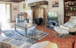 a living room with a couch and a tv at Awesome Home In Souvigne With 5 Bedrooms, Private Swimming Pool And Heated Swimming Pool in Souvigné