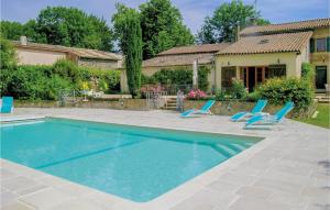a swimming pool with two blue chairs and a house at Awesome Home In Souvigne With 5 Bedrooms, Private Swimming Pool And Heated Swimming Pool in Souvigné