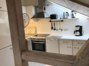 a kitchen with white cabinets and a stove top oven at Ferienwohnungen Am Elfenstein in Bad Harzburg