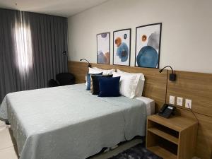 a bedroom with a large bed with blue pillows at Flat Aconchegante - Granja Brasil Resort - Itaipava in Petrópolis