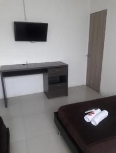 a room with a bed and a desk and a television at buenavista class in Barranquilla