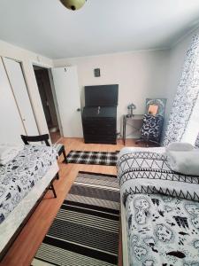 sala de estar con 2 camas y TV de pantalla plana en Room in Guest room - Black-white Rm By Yale U, en New Haven
