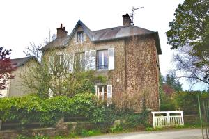 een oud stenen huis met een wit hek ervoor bij La Hogue au blanc in Carolles