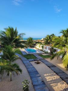 a resort with a swimming pool and palm trees at Condomínio Shalom Beach in Canoa Quebrada