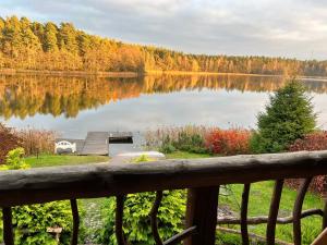 uma vista para um lago com uma doca de madeira em Domwigierski pl -Tobołowo GR -nad samym brzegiem jeziora z sauną- klimatyzacja em Tobołowo