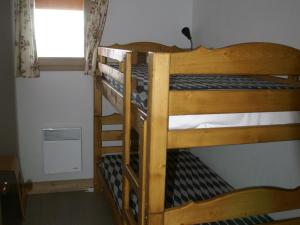 two bunk beds in a room with a window at Appartement haut de gamme 3P cabine, pied des pistes, balcon, parking, centre station à 150m - FR-1-557-15 in Les Adrets
