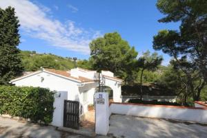 uma casa branca com um portão e uma cerca em Villa Las Hiertas - 6-8 personnes - vue mer em Alcossebre