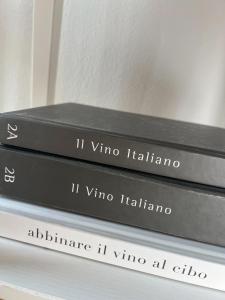 three books stacked on top of each other on a shelf at B&B Nero Buono in Cori