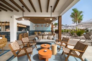 卡萊塔德菲斯泰的住宿－Barceló Fuerteventura Royal Level - Adults Only，一个带椅子和沙发的户外庭院