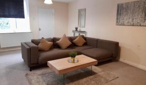 - un salon avec un canapé brun et une table basse dans l'établissement Alexander Apartments North Shields, à South Shields