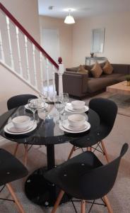 - une table noire avec des chaises et des verres à vin dans l'établissement Alexander Apartments North Shields, à South Shields