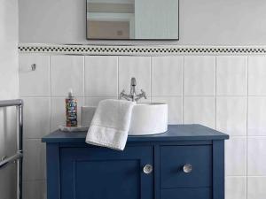 a bathroom with a sink and a blue cabinet at Cosy Georgian Cottage - Parking - Central Frome in Frome