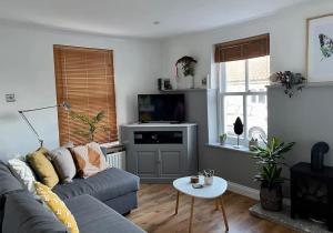 a living room with a couch and a table at Cosy Georgian Cottage - Parking - Central Frome in Frome