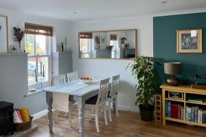 a dining room with a white table and chairs at Cosy Georgian Cottage - Parking - Central Frome in Frome