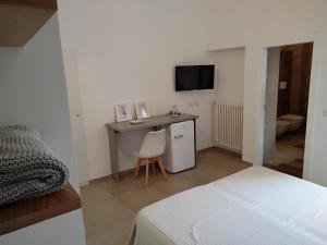 a bedroom with a desk with a chair and a television at B&B Corso Trieste e Trento in Alberobello
