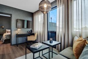 a hotel room with a couch and a desk and a bed at Origo Leilighetshotell- Øvre Storgate 5 in Drammen