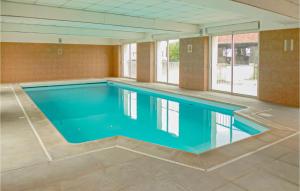 a large swimming pool with blue water in a building at Lovely Home In Vaudoy-En-Brie With Wifi in Vaudoy-en-Brie