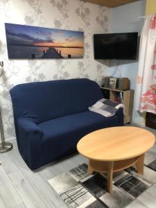 uma sala de estar com um sofá azul e uma mesa em Ferienwohnung "Roter Sand" em Burhave