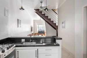 a kitchen with a sink and a staircase at Juquehy - Casa Espaçosa em Condomínio in Juquei