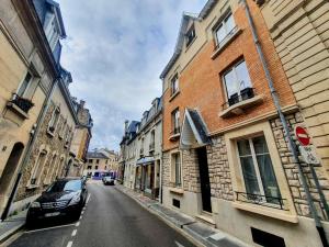 une voiture garée dans une rue de la ville avec des bâtiments dans l'établissement Appartement Premium dans une belle demeure - Hyper centre-ville de Reims, à Reims