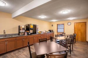 a restaurant with tables and a kitchen with a counter at Red Roof Inn Des Moines in Des Moines