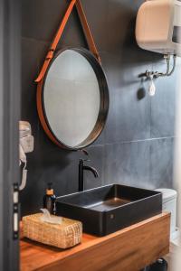 baño con lavabo negro y espejo en The Banyu House en Bandung