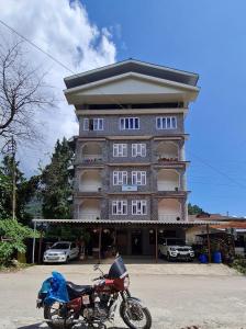 a motorcycle parked in front of a large building at Hotel Himsagar in Pemayangtse