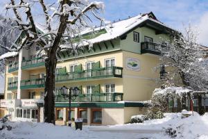un gran edificio con nieve en el suelo en Hotel Alte Post, en Feld am See