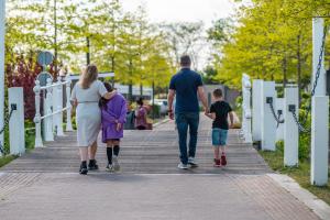 una familia caminando por una pasarela con su hijo en EuroParcs Veluwemeer en Nunspeet