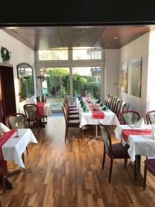 Hotel Martina في باد سودين-أليندورف: غرفة طعام مع طاولة وكراسي طويلة