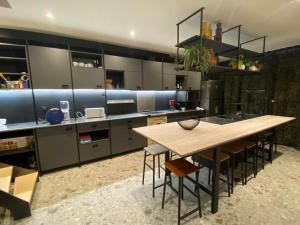 a large kitchen with a wooden table and chairs at Maison de vacances la Grange 20 min de namur in Villeret