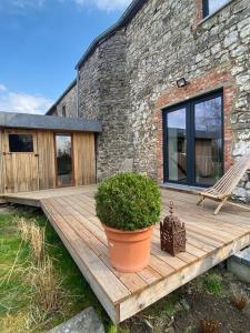 a wooden deck in front of a brick building at Maison de vacances la Grange 20 min de namur 