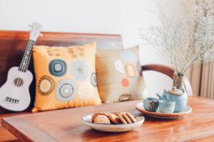 uma mesa com uma tigela de pão e uma guitarra em Anstay Homestay & Apartment em Da Nang