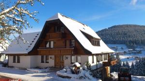 a log cabin with snow on the roof at Martina Frey Ferienwohnungen in Baiersbronn