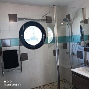 a bathroom with a shower and a round window at Appartement Ti Bato in Les Trois-Îlets