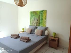 ein Schlafzimmer mit einem großen Bett mit Kissen darauf in der Unterkunft Appartement Ti Bato in Les Trois-Îlets