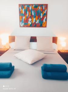 Una cama con dos almohadas y un cuadro encima. en Appartement Ti Bato en Les Trois-Îlets