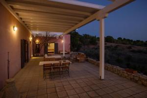 a patio with a table and chairs at night at Roxanne's Olive Grove House in Kranidi