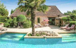 a swimming pool with a palm tree in front of a house at Nice Home In Fleurac With 3 Bedrooms, Outdoor Swimming Pool And Swimming Pool in Fleurac