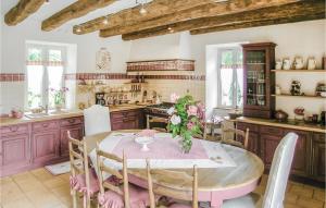 a kitchen with a table with a vase of flowers on it at Nice Home In Fleurac With 3 Bedrooms, Outdoor Swimming Pool And Swimming Pool in Fleurac